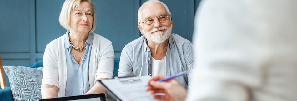 Senior couple meeting with a financial consultant to review their options for cancer care financial assistance.