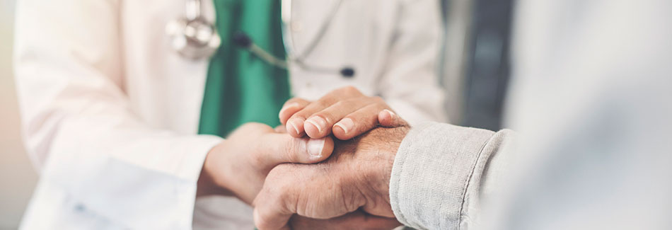 A patient and doctor clasp hands while discussing radiation oncology treatment