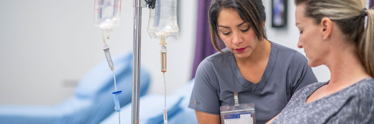 A nurse tends to a cancer patient receiving chemotherapy through an IV – just one of many cancer care services offered at Baptist Cancer Center. 